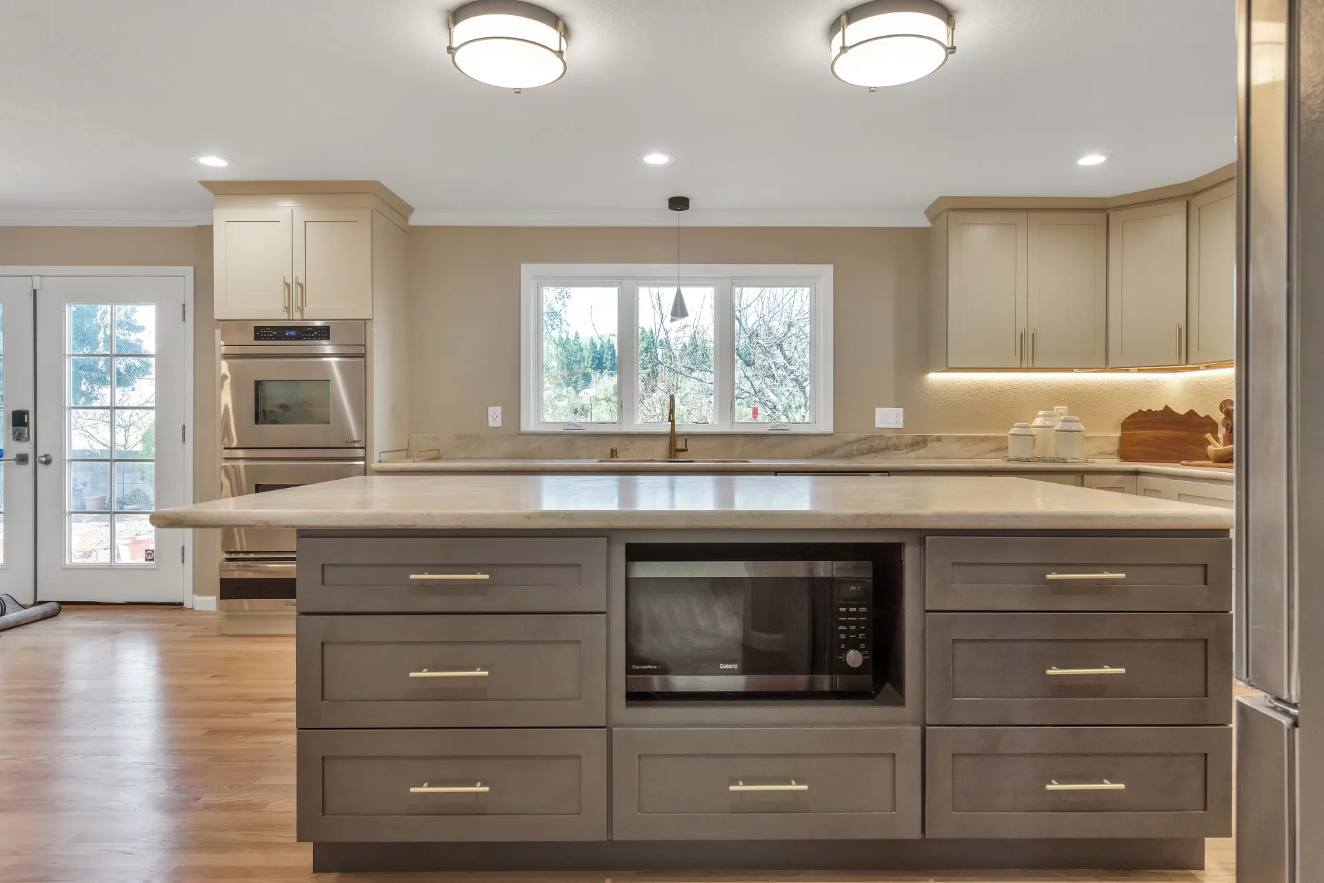 Waterfall quartz island detail with gold hardware — Danville kitchen remodel by Inspired Builders